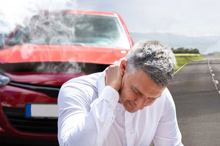 Man Suffering From Neck Pain In Front Of Breakdown Car